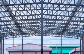 Metal roof beam and columns of incomplete warehouse building structure in construction site